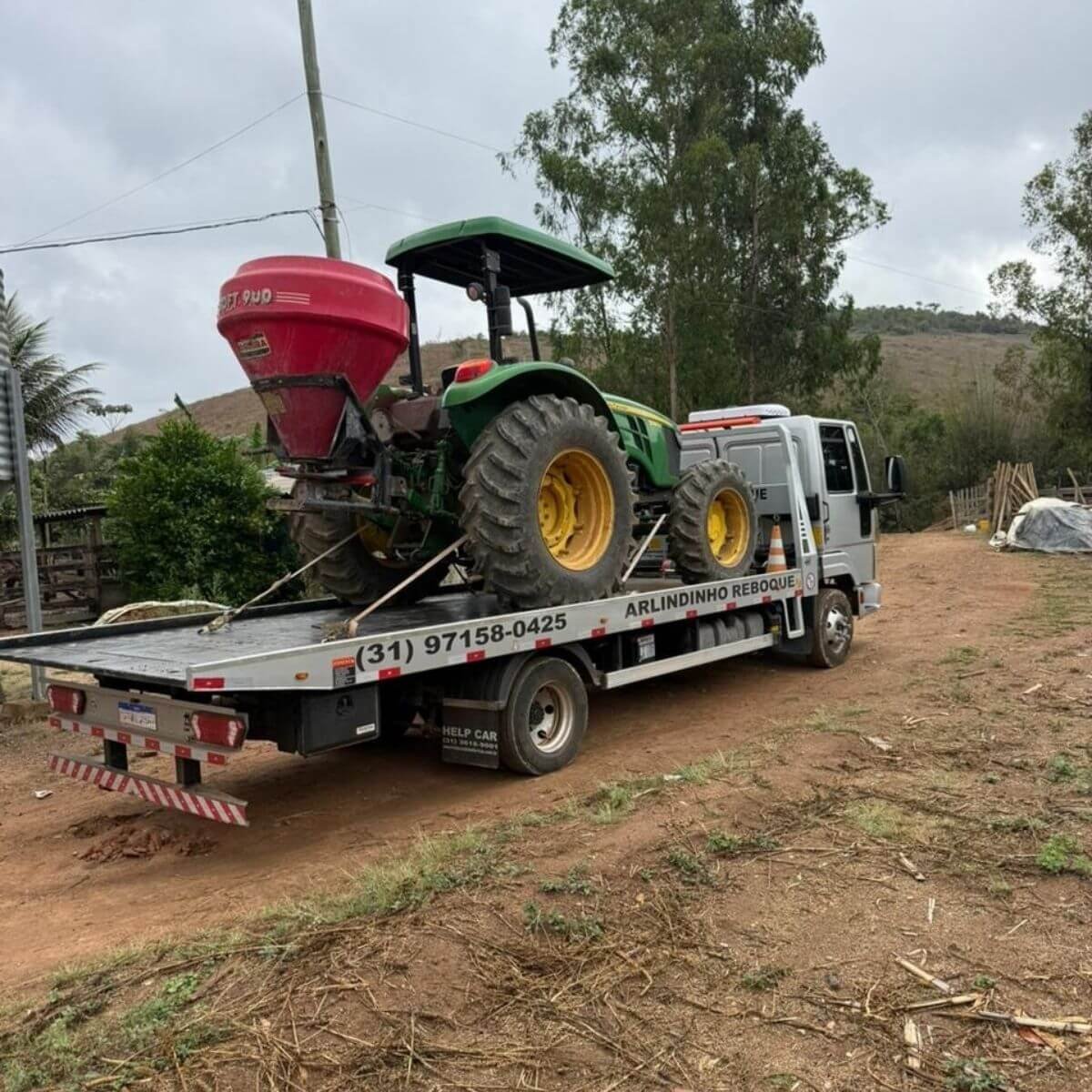 Transporte de trator agrícola John Deere em estrada rural de Mariana.