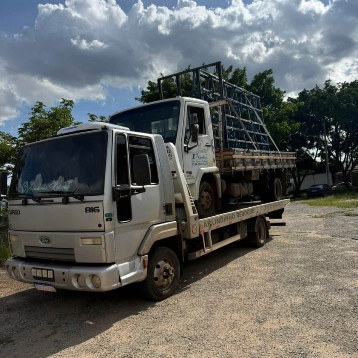 Guincho transportando estrutura de caminhão gaiola em dia nublado.